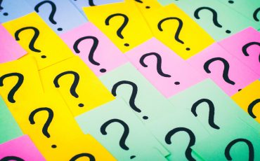 Question marks background. Colorful paper notes with question marks. Concept image. Closeup top view toned.